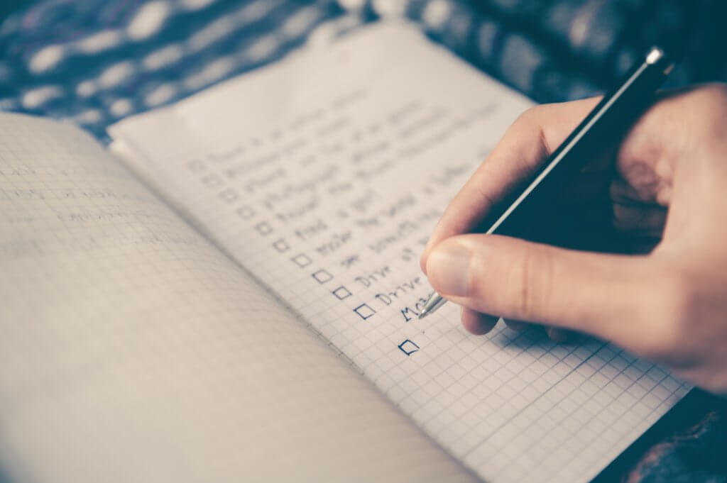 A hand ticking off items on a list